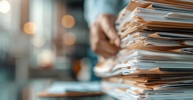 large stack of papers and files on desk
